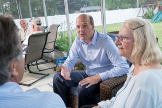 Kevin Hertel having a conversation with constituents on a porch